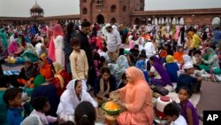 An Indian Muslim woman prepares fruit salad with which she along with her family breaks their day-long fast during Ramadan at the Jama Masjid in New Delhi, India, Friday, June 1, 2018. Muslims across the world are observing the holy fasting month of Ramadan. (AP Photo/Manish Swarup)