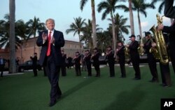 President Donald Trump listens to the Palm Beach Central High School Band as they play at his arrival at Trump International Golf Club in West Palm Beach, Florida, Feb. 5, 2017. Trump will host Japanese Prime Minister Shinzo Abe at his club on Saturday.
