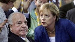 In this Friday, Oct. 1, 2010 file photo, German Chancellor Angela Merkel, right, and the former German Chancellor Helmut Kohl, left, react during a 20 year reunification anniversary meeting of the German Christian Democratic Party in Berlin, Germany. (AP