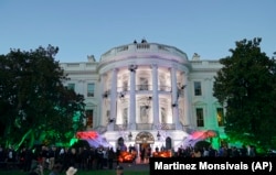 白宫装饰着蜘蛛网、蝙蝠和刻有乔治·华盛顿等前总统形象的橘黄色大南瓜，招待参加万圣节前夜活动的特别来宾(2017年10月31日)。