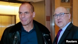 French Finance Minister Michel Sapin (R) and Greek Finance Minister Yanis Varoufakis pose before a meeting at the Bercy Finance Ministry in Paris, Feb. 1, 2015. 