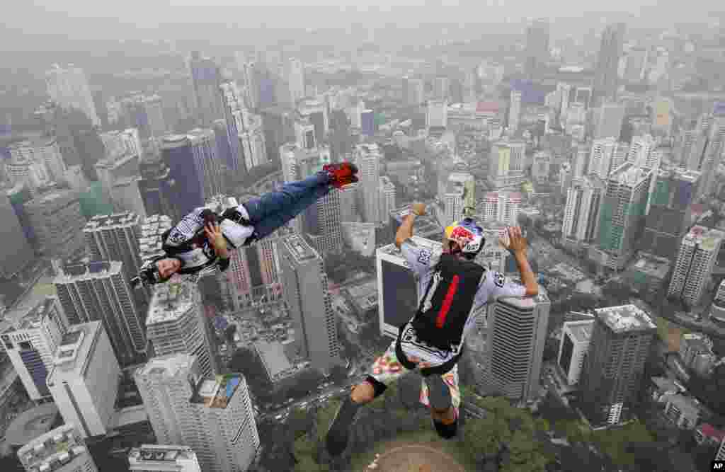 Base jumper Jean-Philippe Marie Teffaud, left, and his team mate Frederic Yves Fugen of France leap from the 300-meter Open Deck of the Malaysia's landmark Kuala Lumpur Tower during the International Tower Jump in Kuala Lumpur.