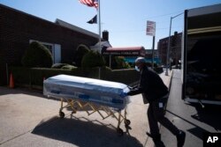 Seorang petugas mengantarkan peti jenazah ke Rumah Duka Gerard Neufeld selama pandemi virus corona di wilayah Queens, New York, 27 Maret 2020. (Foto: dok).