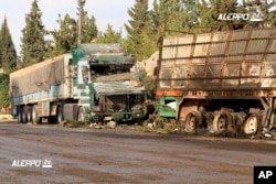 This image provided by the Syrian anti-government group Aleppo 24 news, shows damaged trucks carrying aid, in Aleppo, Syria, Tuesday, Sept. 20, 2016.