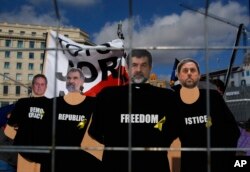 FILE - Pictures of the politicians imprisoned are displayed during a protest at the Catalunya square in Barcelona, Spain, Feb. 18, 2018.