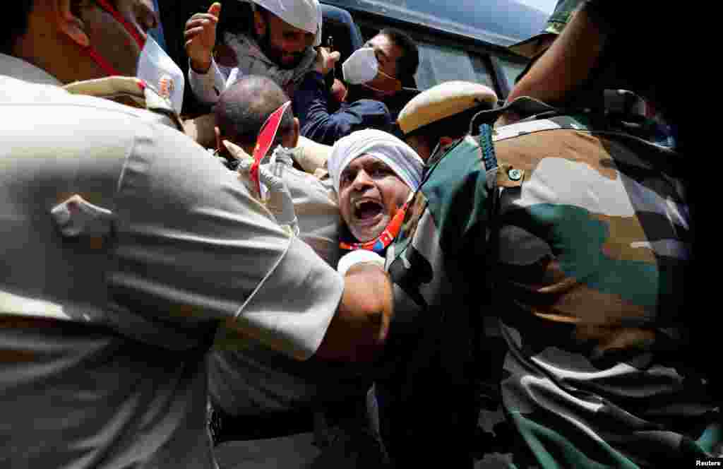 Police officers detain an activist from Swadeshi Jagran Manch, a wing of the Hindu nationalist organisation Rashtriya Swayamsevak Sangh (RSS), during a protest against China, in New Delhi, India.