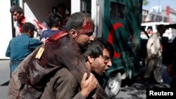 A man carries an injured attack victim to a hospital after a blast in Kabul, Afghanistan May 31, 2017. 