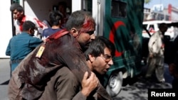 An Afghan man carries an injured man to a hospital after a blast in Kabul, Afghanistan, May 31, 2017. 