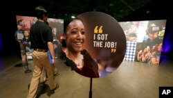 FILE - Job seekers walk into the Opportunity Fair and Forum employment event in Dallas, Texas, May 19, 2017.