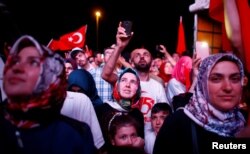 People listen to the speech of Turkey's President Recep Tayyip Erdogan during a ceremony marking the first anniversary of a coup attempt at the Bosporus Bridge in Istanbul, July 15, 2017.