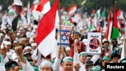 Protesters hold signs during a rally to condemn U.S. President Donald Trumps's decision to recognize Jerusalem as Israel's capital, at Monas, the national monument, in Jakarta, Indonesia, Dec. 17, 2017.