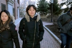 Xiaoning Sui, tengah, warga negara China yang tinggal di British Columbia, Kanada, meninggalkan pengadilan federal, Jumat, 21 Februari 2020, di Boston, setelah mengaku bersalah membayar $400.000 untuk memasukkan putranya ke Universitas California, Los Angeles. (Foto: AP)