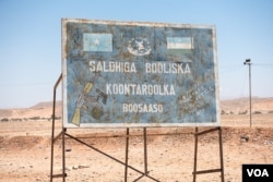 A sign marks a checkpoint and warns against illegal weapons in the desert leading to the city of Bossaso in the semi-autonomous state of Puntland in northern Somalia, March 25, 2018. (J. Patinkin/VOA)