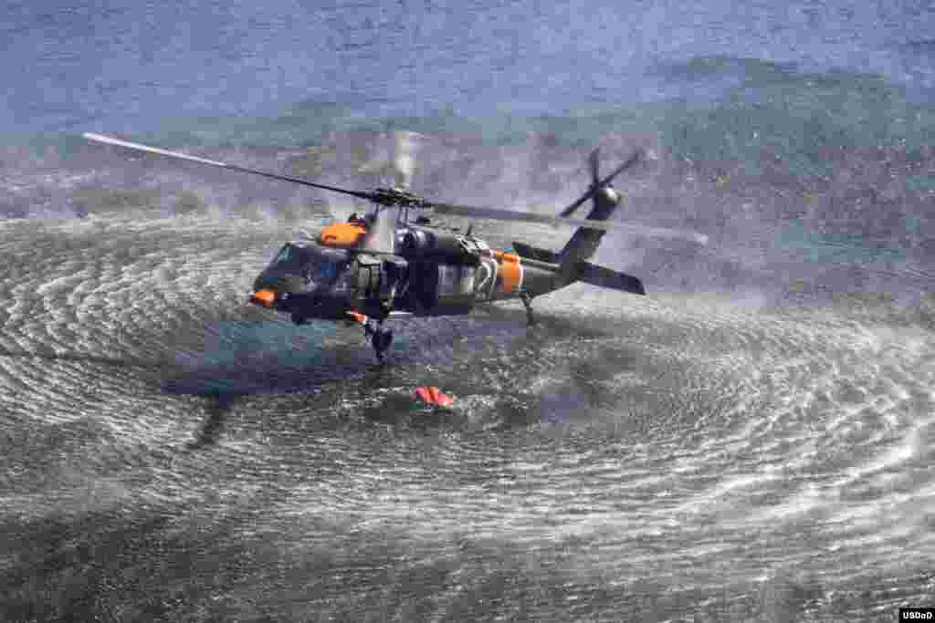 A U.S. Army UH-60 Black Hawk helicopter attached to the 2nd Battalion, 211th Aviation Regiment, Utah Army National Guard collects water from a reservoir while fighting a wildfire in Summit County, Utah, USA, Aug. 15, 2013. (U.S. Army National Guard photo by Ileen Kennedy)