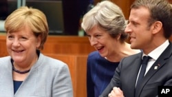 지난달 19일 브뤼셀에서 열린 EU 정상회의에서 테레사 메이 영국 총리가 앙겔라 메르켈 독일 총리, 에마뉘엘 마크롱프랑스 대통령과 대화하고 있다.