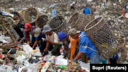 FILE - Pemulung mencari barang untuk didaur ulang di tempat pembuangan sampah di Desa Galuga, Bogor, Jawa Barat, 3 Juni 2013. (REUTERS/Supri)