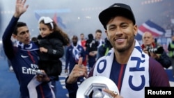 L'attaquant brésilien Neymar tient son trophée après avoir remporté le titre de champion de France L1 à la fin du match de football L1 français PSG vs Rennes, le 12 mai 2018.