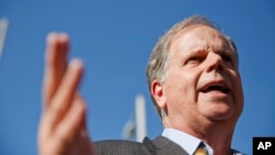 Alabama Democrat Senate candidate Doug Jones speaks to the media, Nov. 14, 2017, in Birmingham, Alabama. President Donald Trump attacked Jones as a lawmaker who would be a "puppet" to party leaders if he is elected next month.