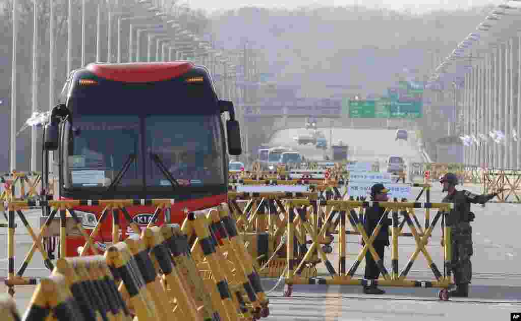 2013年4月26日，一名韩国士兵在通往韩国坡州板门店边界区附近的通往非军事区的统一桥上与一名旅游大巴的司机交谈。