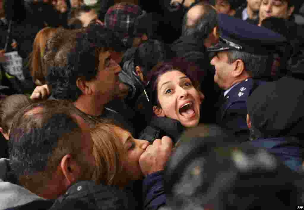 A Cyprus Airways employee shouts as she is pushed against a police line at the Ministry of Finance in Nicosia during a protest against the closing down of Cyprus Airways.