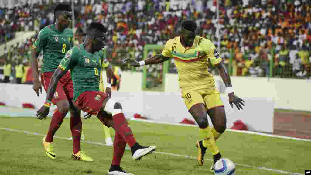 Bakary Sako du Mali, à droite, est aux prises avec Benjamin Moukandjo du Cameroun, à gauche, et Ambroise Oyongo Bitolo, au cours de leur Coupe d&#39;Afrique des Nations match de football du groupe D dans Estadio De Malabo, Guinée équatoriale, mardi 20 janvier 2015.