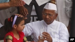 Indian activist Anna Hazare, 73, drinks lime water offered by a child as he breaks his hunger strike in New Delhi, India, April 9, 2011