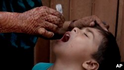 A Pakistani health worker gives a polio vaccine to a child during a campaign in Karachi, Pakistan, Monday, July 25, 2016. (AP Photo)