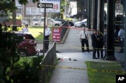 FILE - Authorities investigate the scene of the execution-style murders of two Muslim men in the New York City borough of Queens, Aug. 13, 2016.