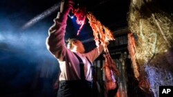 Kori Williams, 17, hangs moose intestines in the smokehouse of the Stevens family hunting camp, Sept. 15, 2021, near Stevens Village, Alaska.