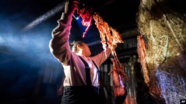 Kori Williams, 17, hangs moose intestines in the smokehouse of the Stevens family hunting camp, Sept. 15, 2021, near Stevens Village, Alaska.
