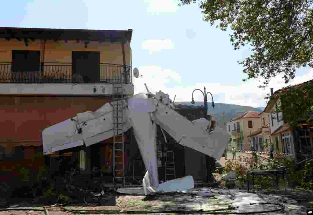 A small plane is seen on a building after a crash in the village of Proti, near Serres town, northern Greece.