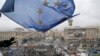 FILE - A supporter waves a European Union flag from a building top in Kyiv, Nov. 29, 2013.