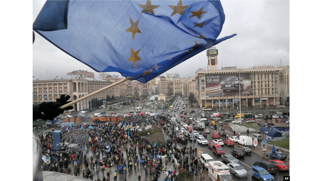A view of a rally in support of integration with the European Union, as a supporter waves a European flag from a building top in Kyiv, Nov. 29, 2013.