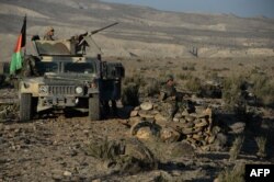 FILE - Afghan security forces take positions following an operation against Islamic State militants in Pachir Agam district of Nangarhar province, Dec. 3, 2016.