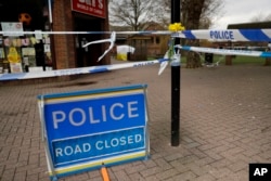 Daffodils are placed by a police cordon backdropped by a tent covering the area where former Russian double agent Sergei Skripal and his daughter were found critically ill, March 13, 2018.