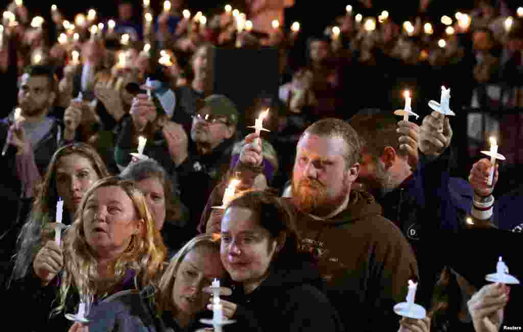 Mourners gather during a candlelight vigil in Amsterdam, upstate New York, for the victims of a limousine accident, Oct. 8, 2018.