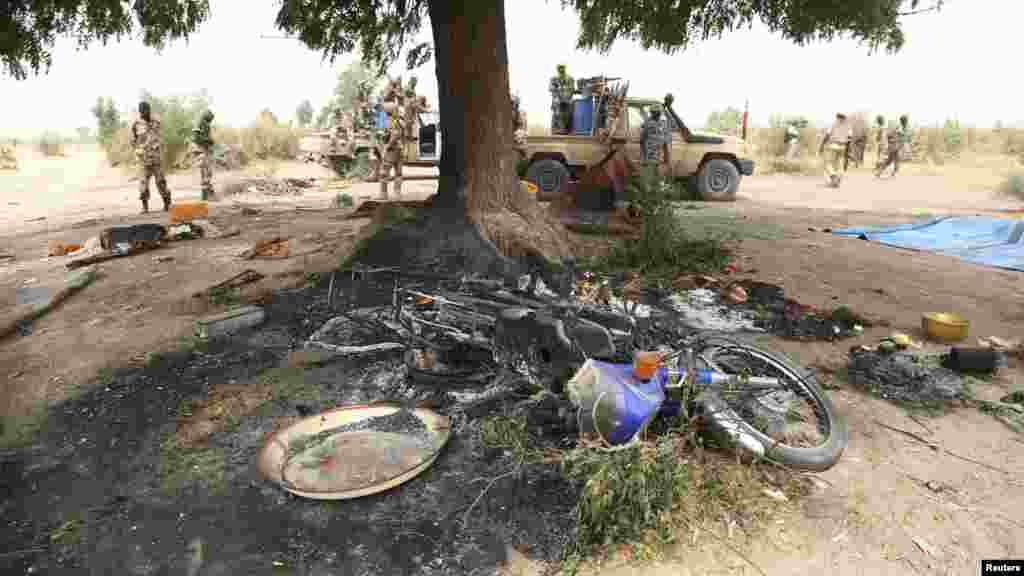 Des soldats tchadiens se tiennent à côté de ce qu&#39;ils disent être un camp du groupe insurgé Boko Haram, que l&#39;armée tchadienne dit avoir détruit dans la bataille de Gambaru, au Nigeria, le 26 février 2015.