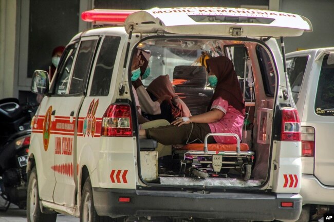 Seorang pasien COVID-19 menunggu di ambulans untuk mendapat giliran perawtan di Rumah Sakit Dr. Sardjito, Yogyakarta, 7 Juli 2021. (Foto: AP)