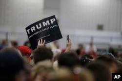 A supporter for Republican presidential candidate Donald Trump holds up a sign during a campaign stop, April 20, 2016, in Indianapolis, Indiana.