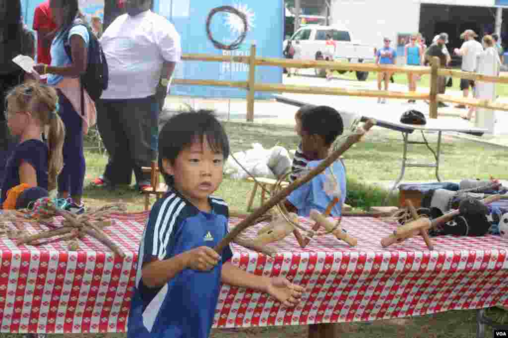 Los niños se divierten con la exhibición de juguetes artesanales.