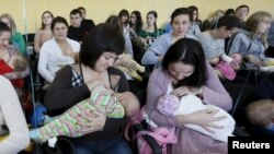 FILE - Mothers breastfeed their babies during a flash mob at a children's polyclinic in the Siberian city of Krasnoyarsk, Russia, Nov. 15, 2015.