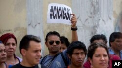 A man holds up a sign that reads in Spanish: "CICIG yes" in reference to the U.N. International Commission Against Impunity, or CICIG, during a protest against Guatemala's President Otto Perez Molina in Guatemala City, April 20, 2015. 