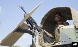 FILE - An Afghan National Army soldier stands guard in his vehicle in Camp Khogyani in Nangarhar province, east of Kabul — a region where homegrown militants loyal to the Islamic State group have made some inroads, in August 2015.