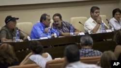 Mauricio Jaramillo, a spokesman and top leader of the Revolutionary Armed Forces of Colombia, or FARC, second from left, talks with FARC member Andres Paris during a press conference in Havana, Cuba, September 6, 2012.