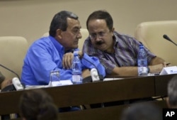 FILE - Mauricio Jaramillo, a spokesman and top leader of the Revolutionary Armed Forces of Colombia, or FARC, left, talks with FARC member Andres Paris during a press conference in Havana, Cuba, Sept. 6, 2012.
