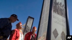 FILE - Navajo Code Talkers from left, Albert Smith, Teddy Draper Sr. and Samuel Tso read the names of their brothers-in-arms written on a pillar dedicated to them during the filming of a documentary about them in Gallup, New Mexico, Oct. 28, 2006. 