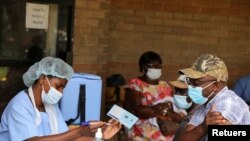 FILE PHOTO: A man receives a certificate after being vaccinated against the coronavirus disease (COVID-19) at Wilkins Hospital in Harare, Zimbabwe, March 24, 2021. REUTERS/Philimon Bulawayo/File Photo