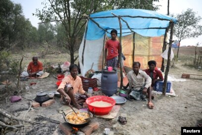 FILE - A man cooks a meal in his makeshift restaurant on the island of Bhasan Char in the Bay of Bengal, Bangladesh, Feb. 14, 2018.
