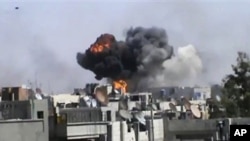 Smoke billows an impact following purported shelling in Khaldiyeh district, Homs, Syria, April 18, 2012.