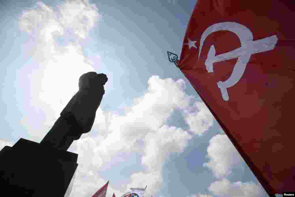 Participants hold a Soviet flag near a statue of Soviet leader Vladimir Lenin during an International Worker&#39;s Day, or Labor Day, parade in the town of Slovyansk, May 1, 2014.